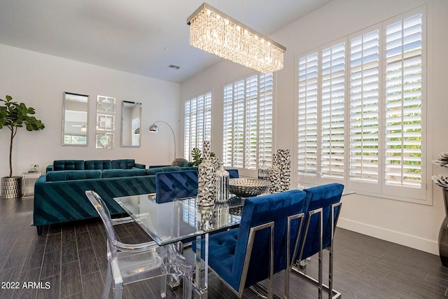 dining space featuring visible vents, baseboards, a chandelier, and wood tiled floor