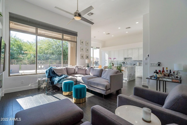 living area featuring dark wood-style flooring, ceiling fan, visible vents, and recessed lighting