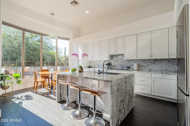 kitchen featuring backsplash, dark wood-style flooring, white cabinetry, and freestanding refrigerator