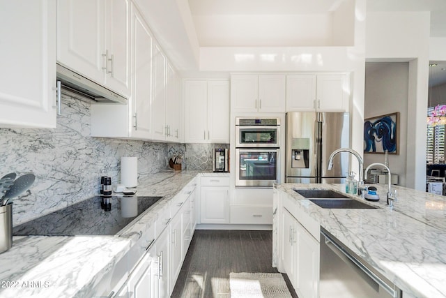 kitchen featuring backsplash, a sink, stainless steel appliances, and light stone counters