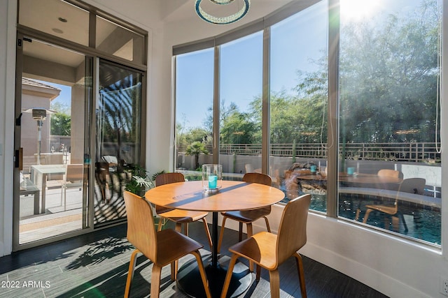 sunroom featuring baseboards and wood finished floors