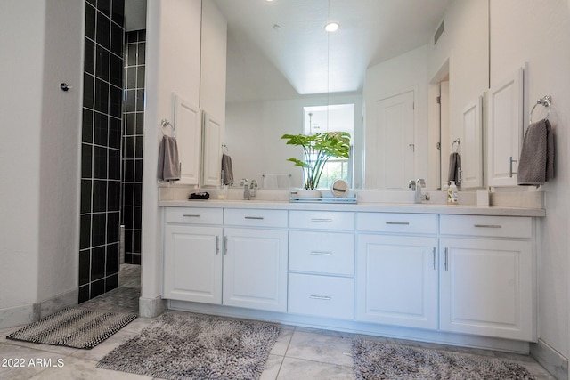 bathroom featuring visible vents, double vanity, and walk in shower