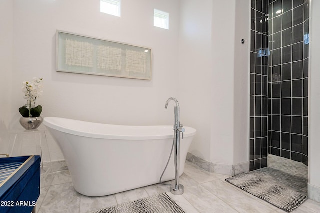 bathroom featuring a soaking tub and a walk in shower