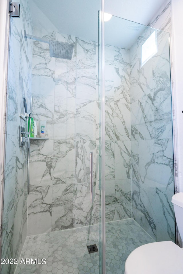full bath featuring a marble finish shower and toilet