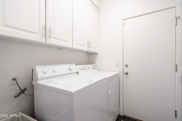 washroom featuring cabinet space and washer and clothes dryer