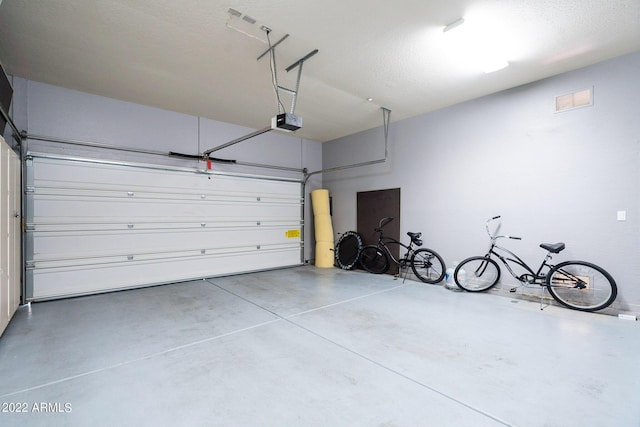 garage featuring visible vents and a garage door opener