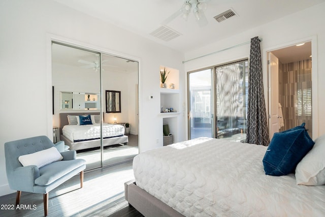 bedroom with a closet, ceiling fan, visible vents, and wood finished floors