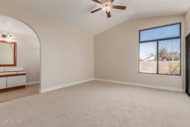 15087 N 86th Dr, Peoria, AZ 85381 - empty room with lofted ceiling, baseboards, arched walkways, a ceiling fan, and light carpet