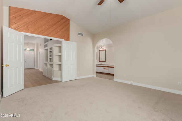 15087 N 86th Dr, Peoria, AZ 85381 - carpeted spare room featuring high vaulted ceiling, visible vents, baseboards, ceiling fan, and arched walkways