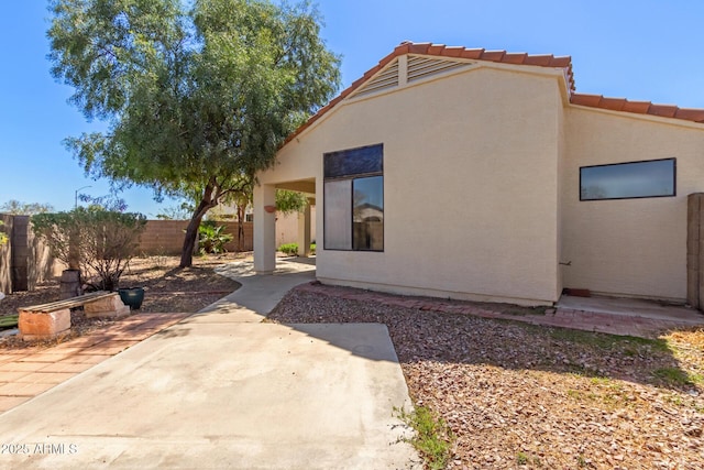 15087 N 86th Dr, Peoria, AZ 85381 - rear view of house with a patio, fence, a tiled roof, and stucco siding