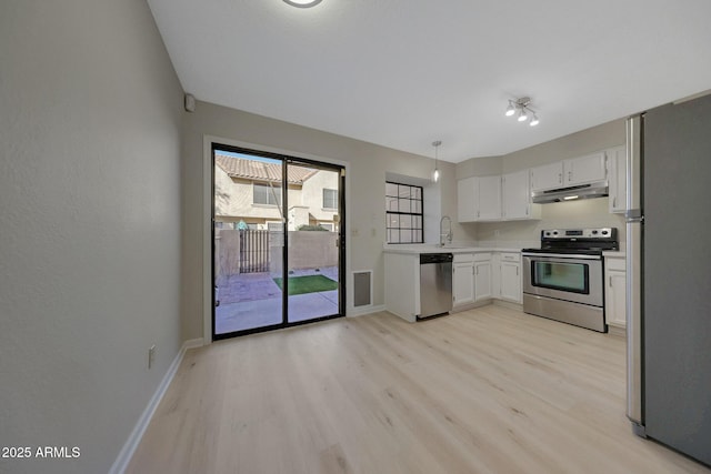 kitchen featuring sink, light hardwood / wood-style flooring, hanging light fixtures, stainless steel appliances, and white cabinets