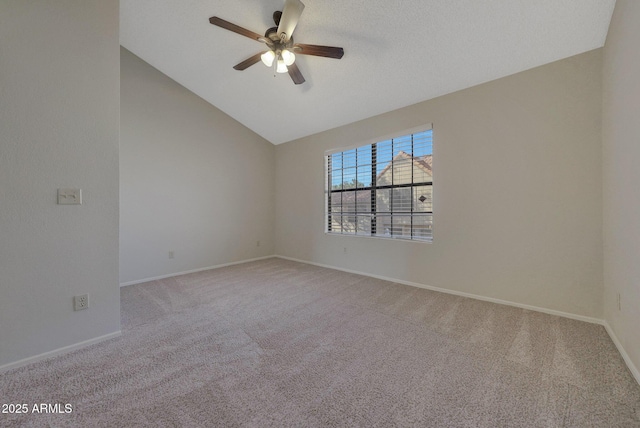 carpeted empty room with vaulted ceiling and ceiling fan