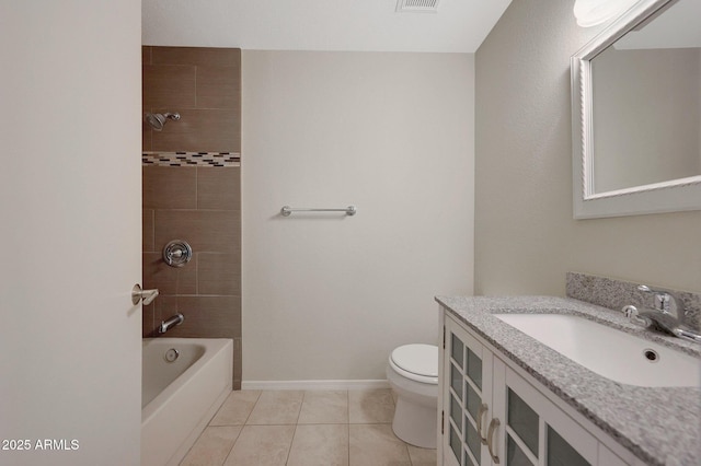 full bathroom featuring tiled shower / bath, vanity, toilet, and tile patterned flooring