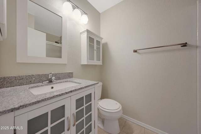 bathroom featuring vanity, a shower with door, tile patterned floors, and toilet