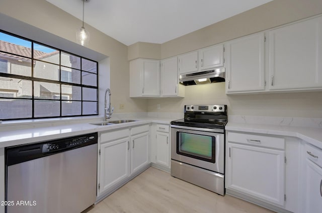 kitchen featuring white cabinetry, appliances with stainless steel finishes, sink, and decorative light fixtures