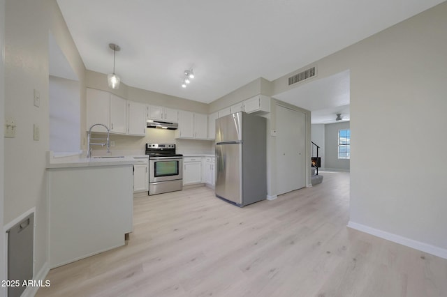 kitchen with hanging light fixtures, white cabinetry, appliances with stainless steel finishes, and sink