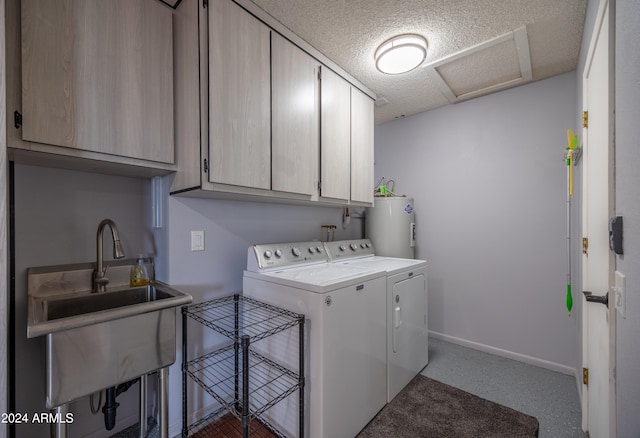 laundry area with cabinets, water heater, a textured ceiling, washer and dryer, and sink