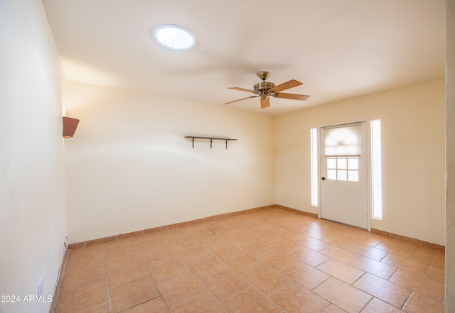 spare room featuring ceiling fan and light tile patterned flooring