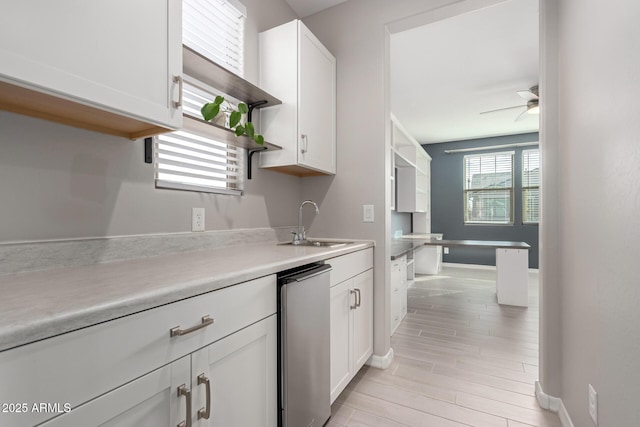 kitchen featuring sink, ceiling fan, refrigerator, white cabinets, and light wood-type flooring