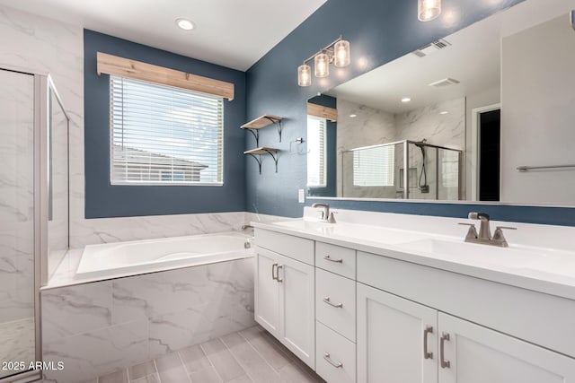 bathroom with vanity and shower with separate bathtub