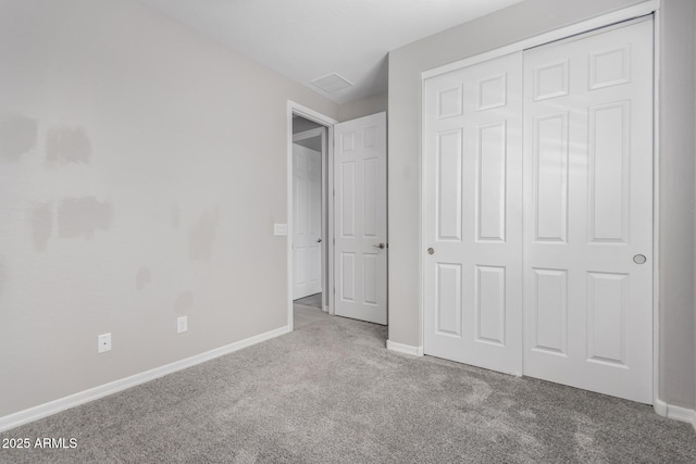 unfurnished bedroom with light carpet and a closet