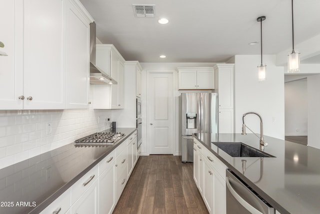 23042 E Excelsior Ave, Queen Creek, AZ 85142 - kitchen featuring appliances with stainless steel finishes, dark countertops, wall chimney exhaust hood, dark wood-style floors, and recessed lighting