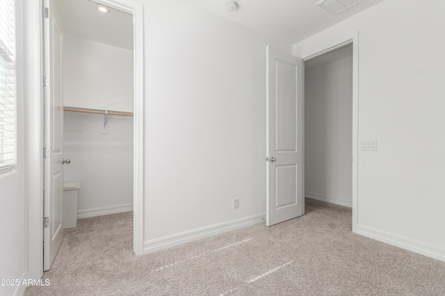 23042 E Excelsior Ave, Queen Creek, AZ 85142 - unfurnished bedroom featuring carpet, multiple windows, a walk in closet, and a closet