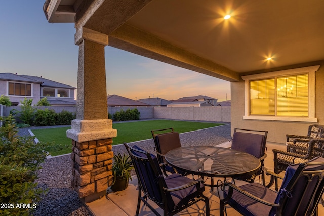 23042 E Excelsior Ave, Queen Creek, AZ 85142 - patio terrace at dusk featuring a fenced backyard, outdoor dining space, and a patio