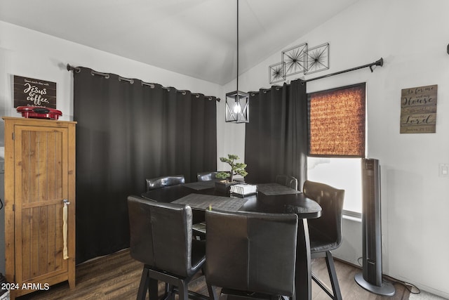 dining space with wood finished floors and vaulted ceiling