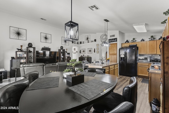 dining room featuring light wood finished floors, visible vents, and a toaster