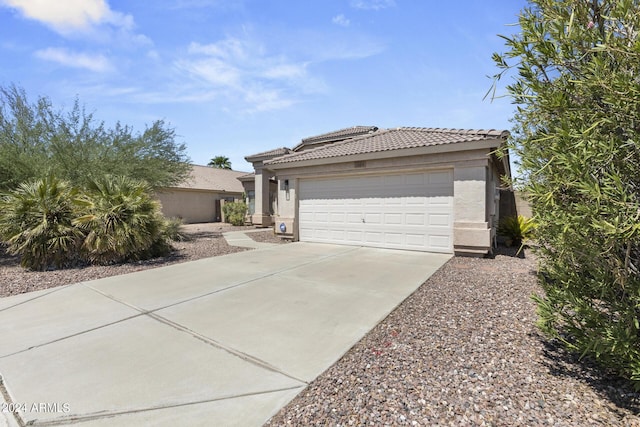 view of front of home with stucco siding, concrete driveway, and a tile roof