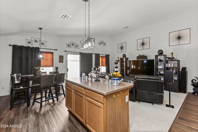 kitchen featuring pendant lighting, a center island, vaulted ceiling, and dark wood-type flooring