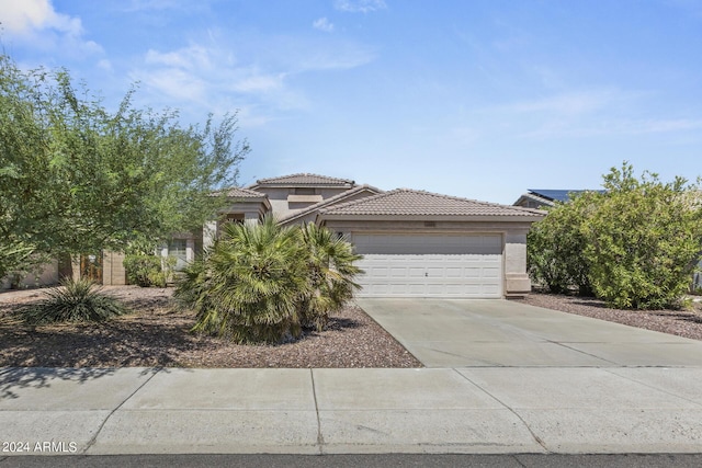 view of front facade featuring stucco siding, concrete driveway, an attached garage, and a tiled roof