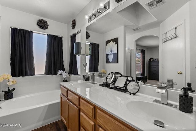 bathroom featuring vanity, hardwood / wood-style flooring, and a washtub