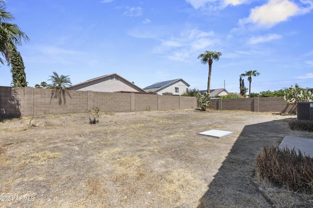 view of yard with central air condition unit and a fenced backyard