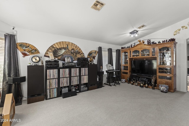 living area featuring visible vents, carpet floors, and lofted ceiling