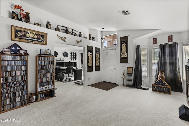 interior space featuring lofted ceiling, visible vents, and carpet floors