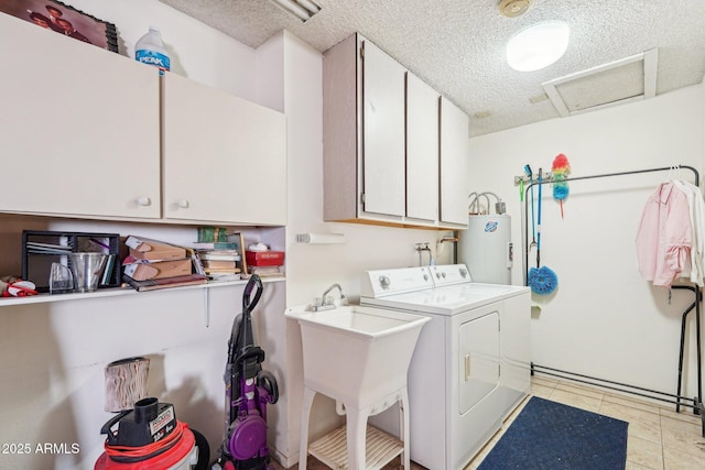 17024 N Pinion Ln, Sun City, AZ 85373 - washroom featuring water heater, attic access, a textured ceiling, cabinet space, and washing machine and dryer