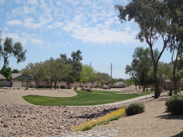 surrounding community with fence and a lawn