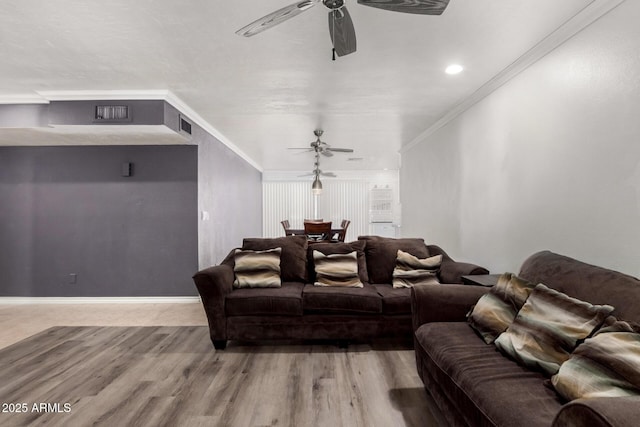 cinema room with baseboards, wood finished floors, a ceiling fan, and crown molding