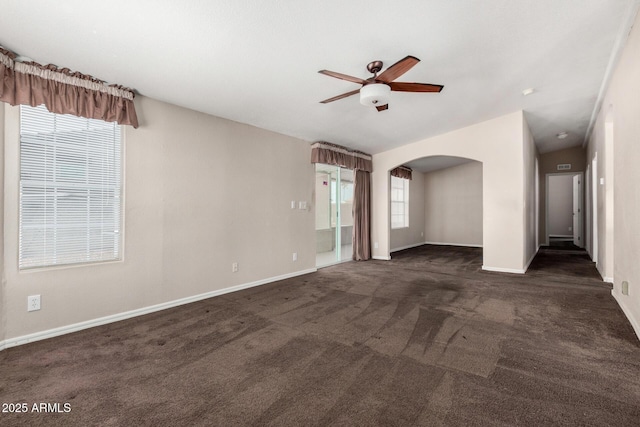 5901 E Leonora St, Mesa, AZ 85215 - spare room featuring arched walkways, dark colored carpet, a ceiling fan, and baseboards