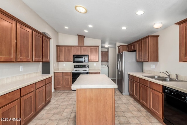 5901 E Leonora St, Mesa, AZ 85215 - kitchen with black appliances, a center island, light countertops, a sink, and washer / dryer