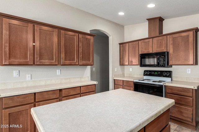 5901 E Leonora St, Mesa, AZ 85215 - kitchen with arched walkways, light countertops, black microwave, recessed lighting, and electric range
