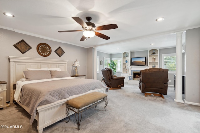 carpeted bedroom with multiple windows, ornamental molding, ornate columns, and ceiling fan