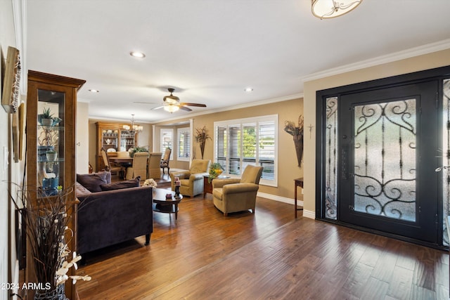 entryway with ornamental molding, dark wood-type flooring, and ceiling fan with notable chandelier