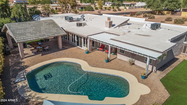 view of swimming pool with a patio and central air condition unit