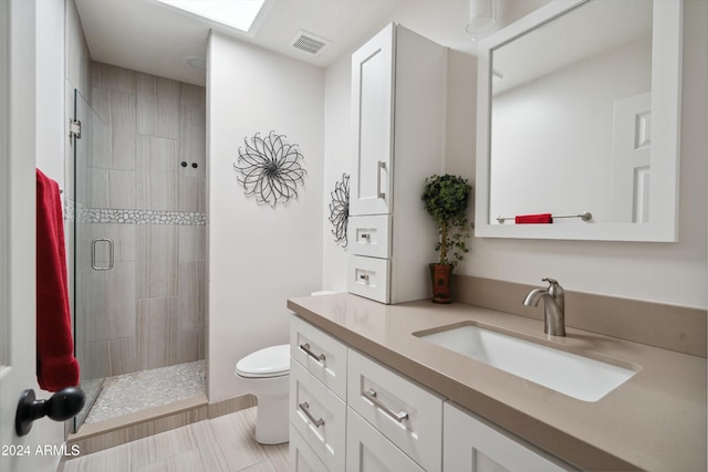 bathroom featuring vanity, tile patterned flooring, toilet, and walk in shower