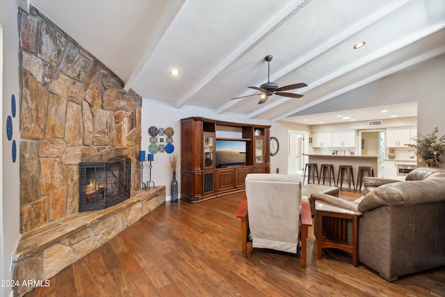 living room featuring lofted ceiling with beams, ceiling fan, a fireplace, and dark hardwood / wood-style flooring