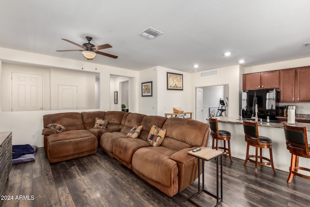 living room featuring ceiling fan and dark wood-type flooring