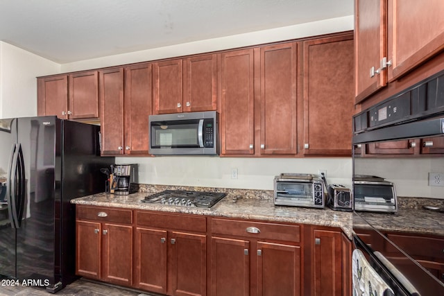 kitchen featuring dark stone countertops and stainless steel appliances